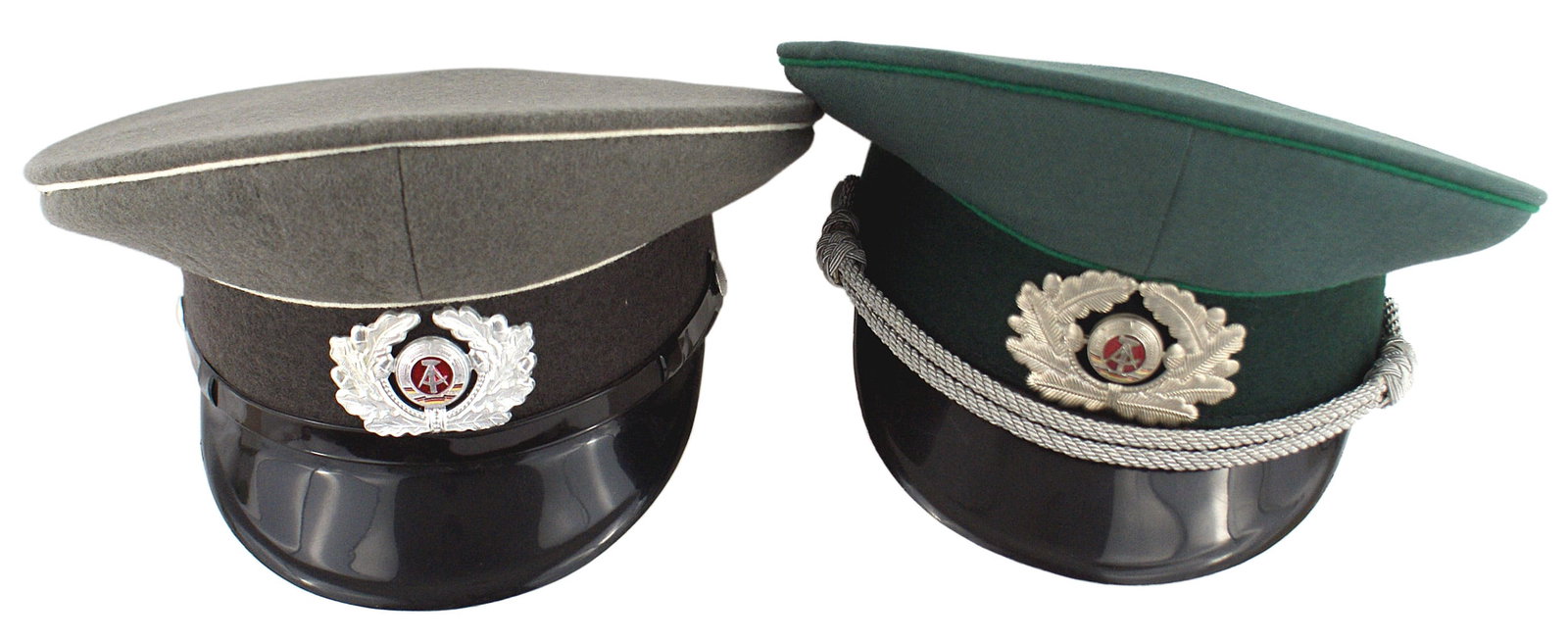 2 DDR German Democratic Republic peaked caps: E-070 Lot of 2 D.D.R. (German Democratic Republic) peaked caps: (1) Infantry Other Ranks. Feld-grau body, gray band and white piping. Silvered oak leaf wreath with national emblem (calipers and hammer