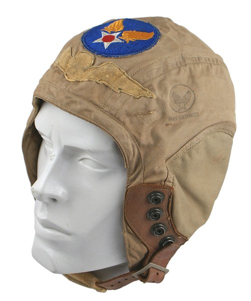 U.S. WWII Army Air Force pilot helmet: E-98 U.S. WWII Army Air Force cloth pilot's helmet. Snap on cushioned leather chinstrap. U.S.AAF "patch" sewn above a chamois silhouette of Pilot's Wings. With cloth label. II
