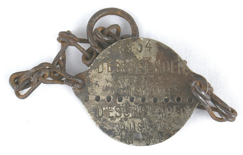 European bracelet dog tag GUSTAV: H-281 European bracelet "dog tag". Round iron disc with a chain attached to an extended "ear" on each side. Perforated center - with number "1934" and name "DESCHEEADER GUSTAV" on each half. The rever