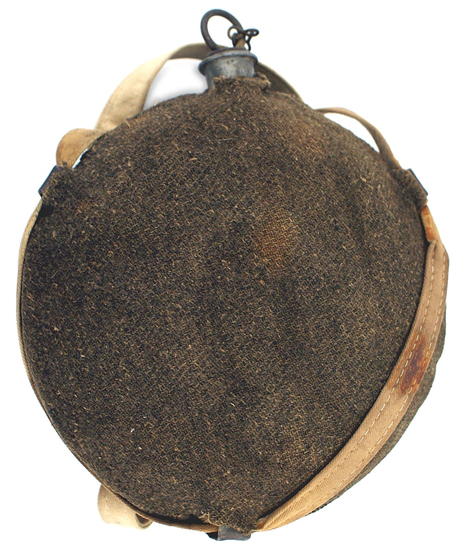 Civil War Federal Regulation canteen: K-034 American Civil War Federal Regulation canteen. Round tin 8" diameter. 2 3/4" thick at center. Pewter spout and cork with a metal cap/ring/safety chain. A dark O.D. woolen cloth is stretched