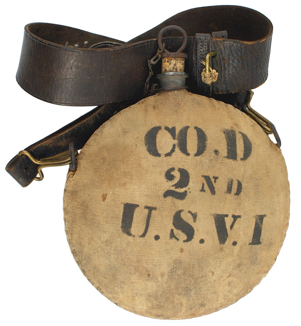 US Spanish American War canteen: K-115 U.S. Spanish-American War canteen. "U.S." on obverse and a reverse "CO. D" - "2ND USVI". Cork stopper has a safety chain. With a leather shoulder strap. II