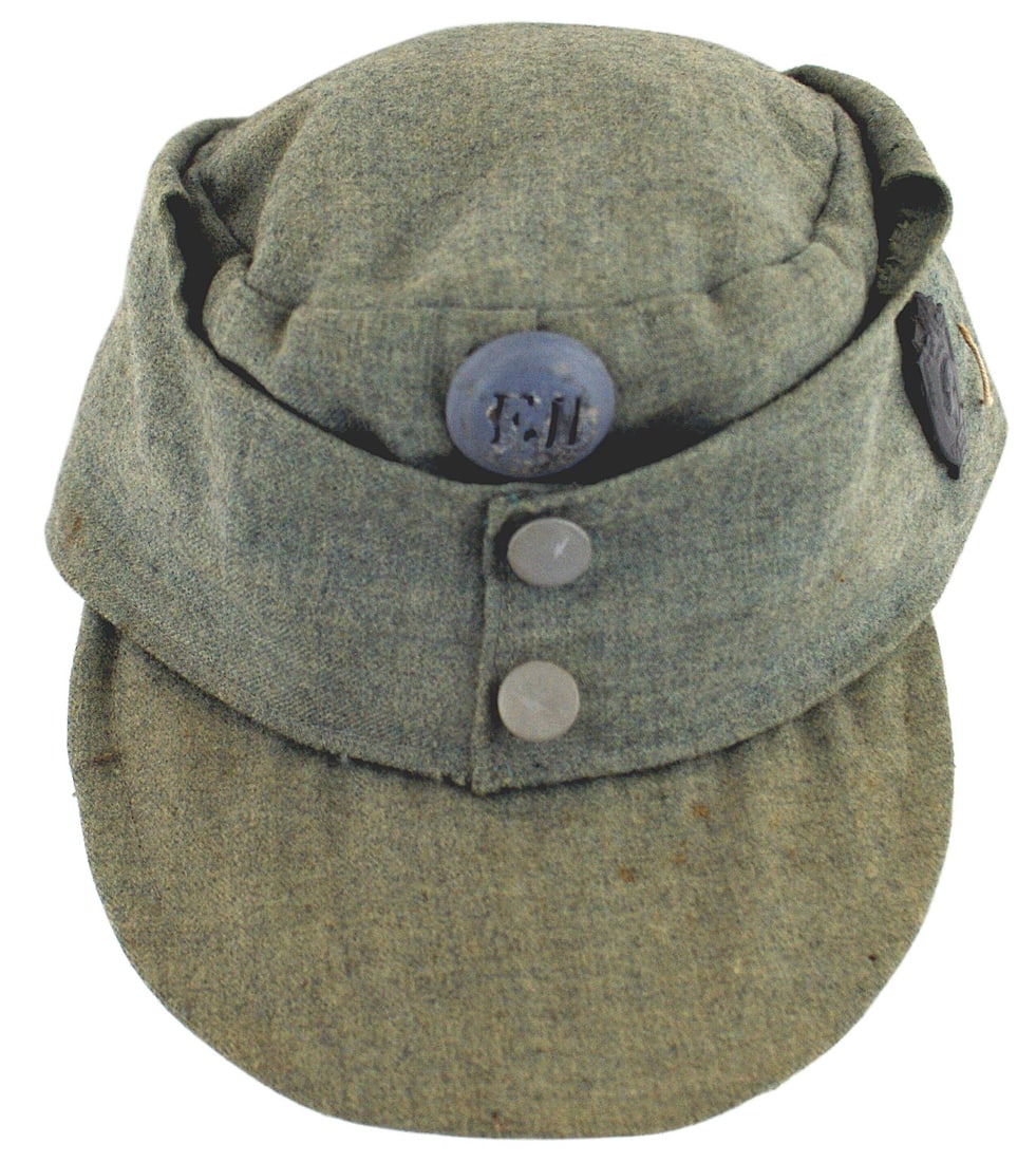Austrian WWI light OD field cap: E-003 Austrian WWI light O.D. field cap. Two button front, when released, pulls down forming ear covers. The German M43 was copied from this cap. White cloth lining. Front button badge "FJI" and a sid