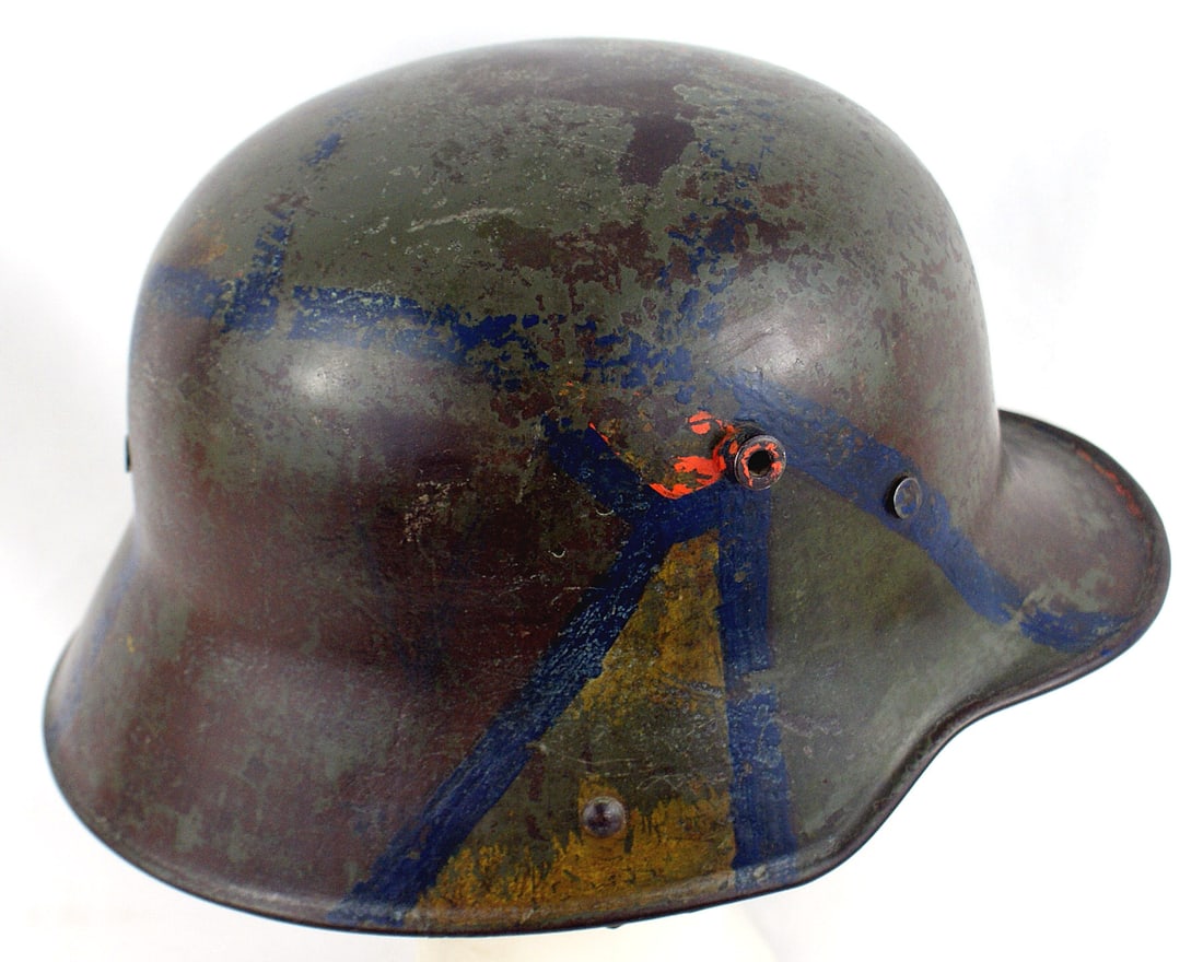 German WWI camouflage M1916 helmet shell: E-012 German WWI camouflage M1916 helmet shell (only). Irregular connected blue lines to separate the colors. Some of the panels have brown residue and one has yellow-orange. The original light green 