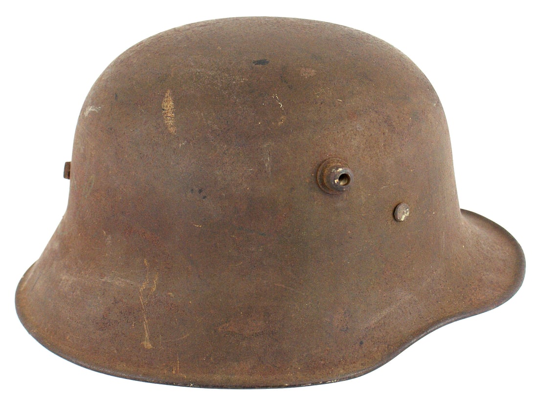 German WWI M1918 helmet: E-013 German WWI M1918 helmet. Some of the original green finish and black lines for camouflage can be seen with the brown light rust "dimples". Metal liner with three pads, with cushions that show so