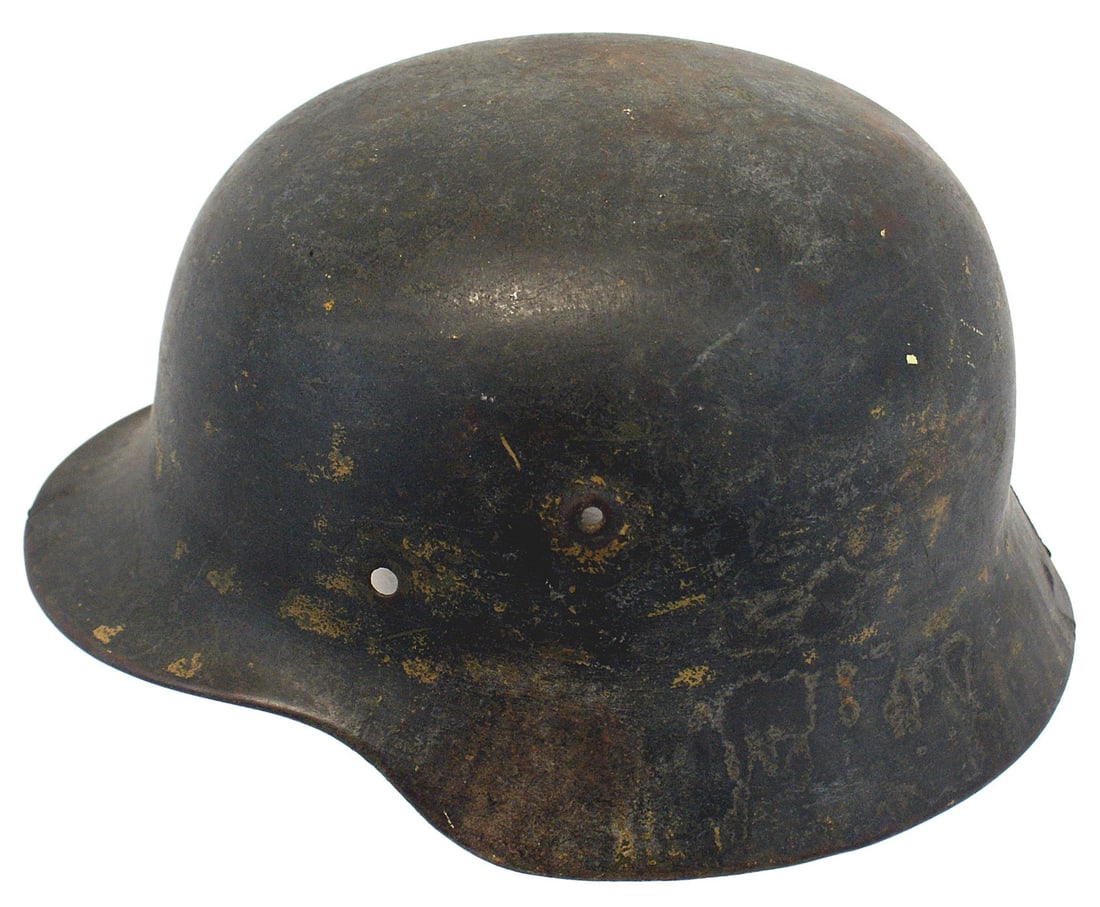 German WWII Army M1940 helmet shell: E-018 German WWII Army M1940 "Stahlhelm" shell. Shows residue of tan finish on the original OD body. Was used by troops in the Afrika Korps or the Mediterranean Theatre. 50% of the interior lighter gr
