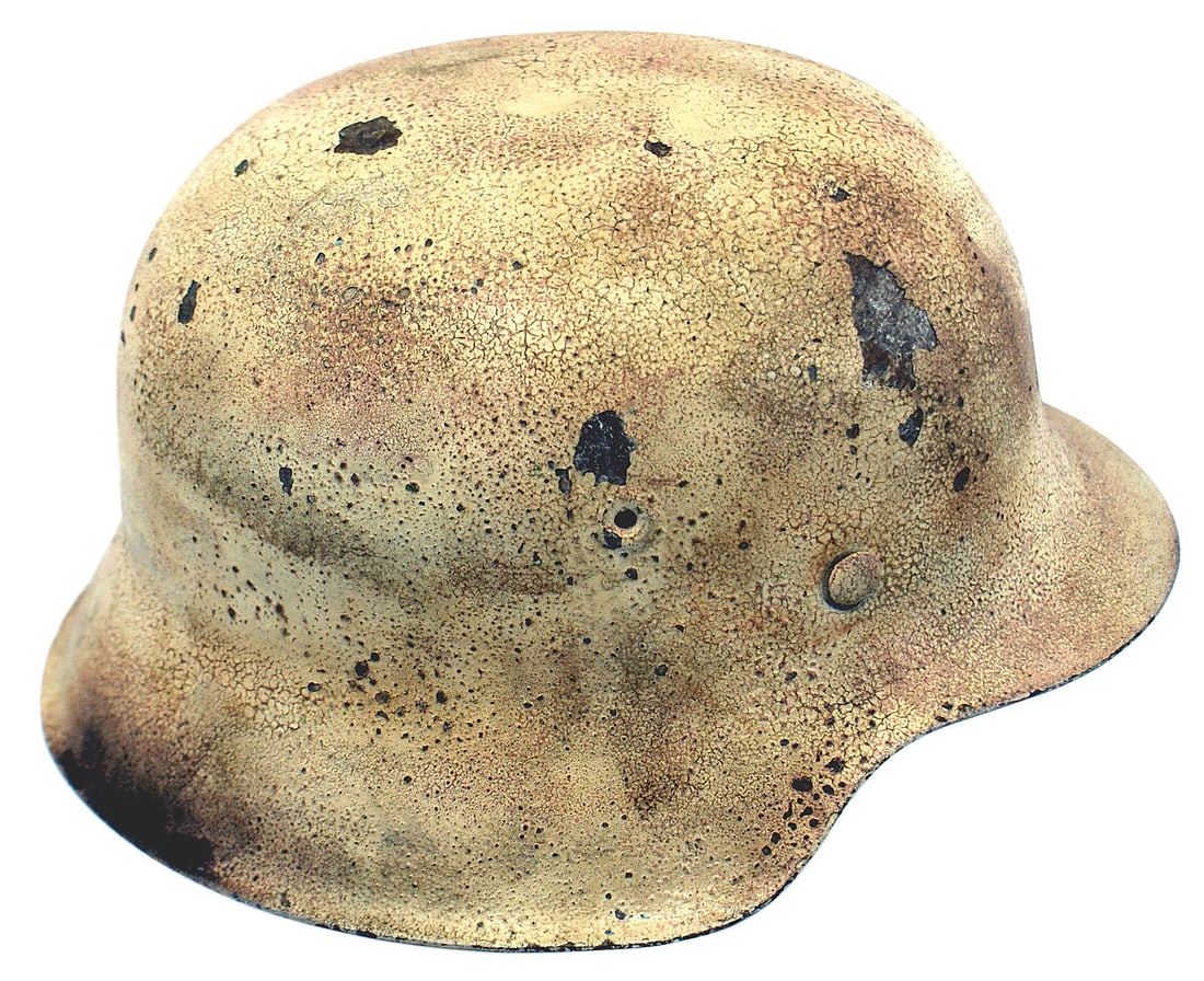 German WWII Army M1942 winter camo helmet: E-020 German Army M1942 winter camouflage helmet. Original finish has toned to an off-white with some light salmon splotches. Aging has given a "crackled" look to the finish. Leather liner and chinstr