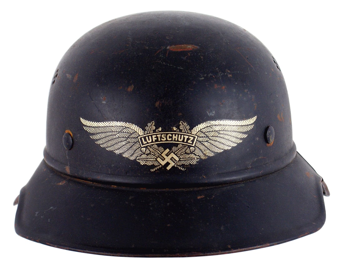 German WWII Luftschutz helmet: E-024 German WWII Luftschutz three-piece helmet. Some small paint chips to the dark blue body. Large winged "LUFTSCHUTZ"/swastika decal. Nine tongue drawstring liner. Shows expected wear. II