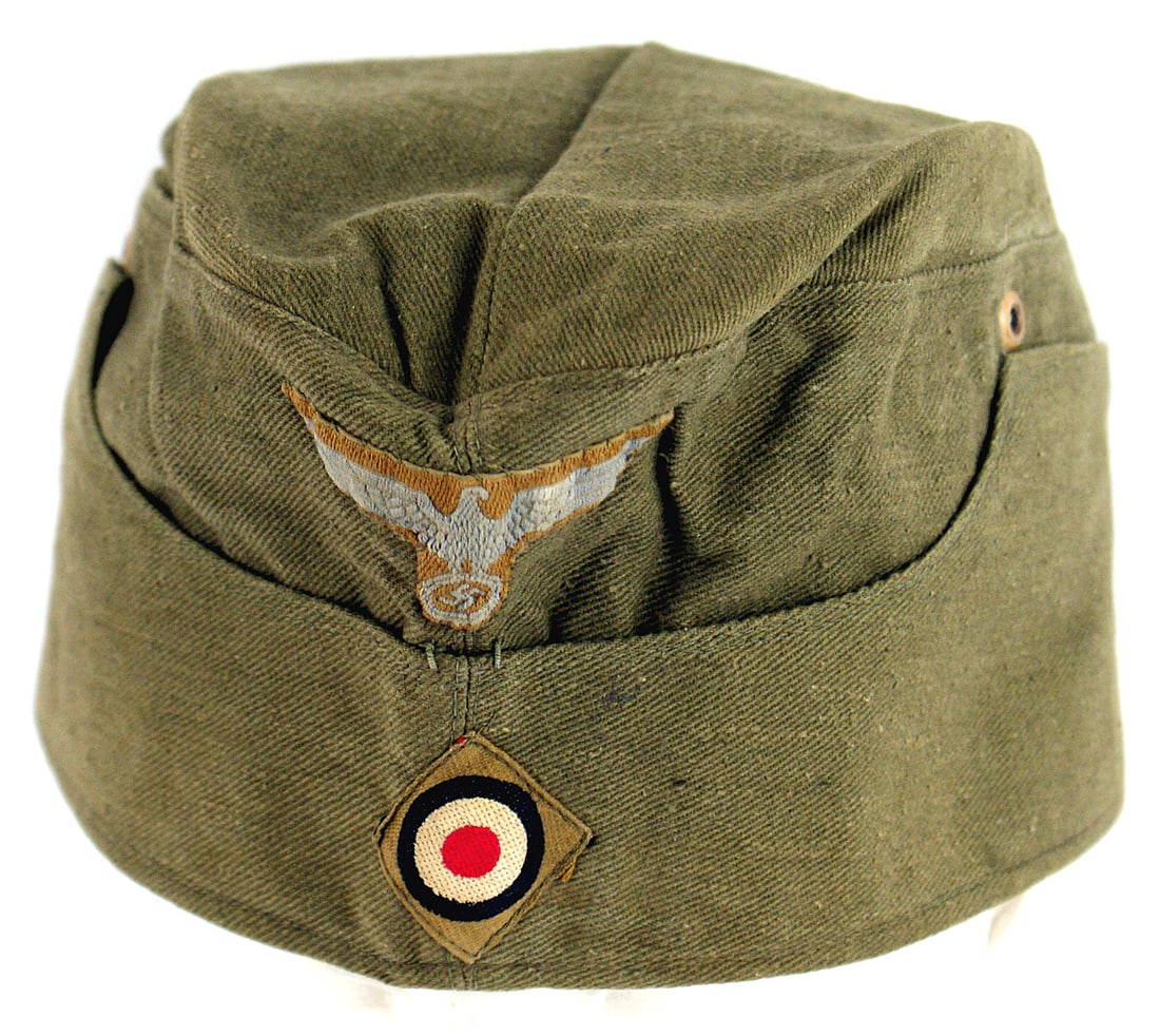 German WWII Afrika Korps EM overseas cap: E-043 German WWII Afrika korps E.M. o'seas cap. O.D. fabric with a sewn bevo AK eagle and rosette. Red cloth lining. Stamped "CLEMENS WAGNER - JAN 43 - BRAUNSCHWEIG". Inside ventilation grommets have 