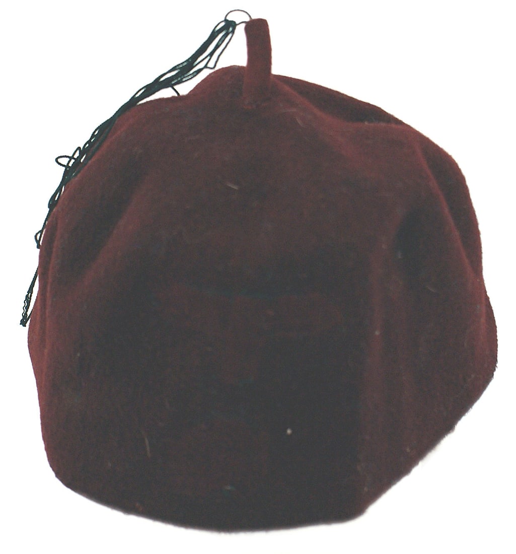 German WWII Waffen SS Islamic Volunteer Fez: E-045 German WWII Waffen-SS, Islamic Volunteer's Fez. Maroon felt like material with a 1" stem at the top. Most of the black tassel threads are missing. Front has a strong, obvious impressions of wher