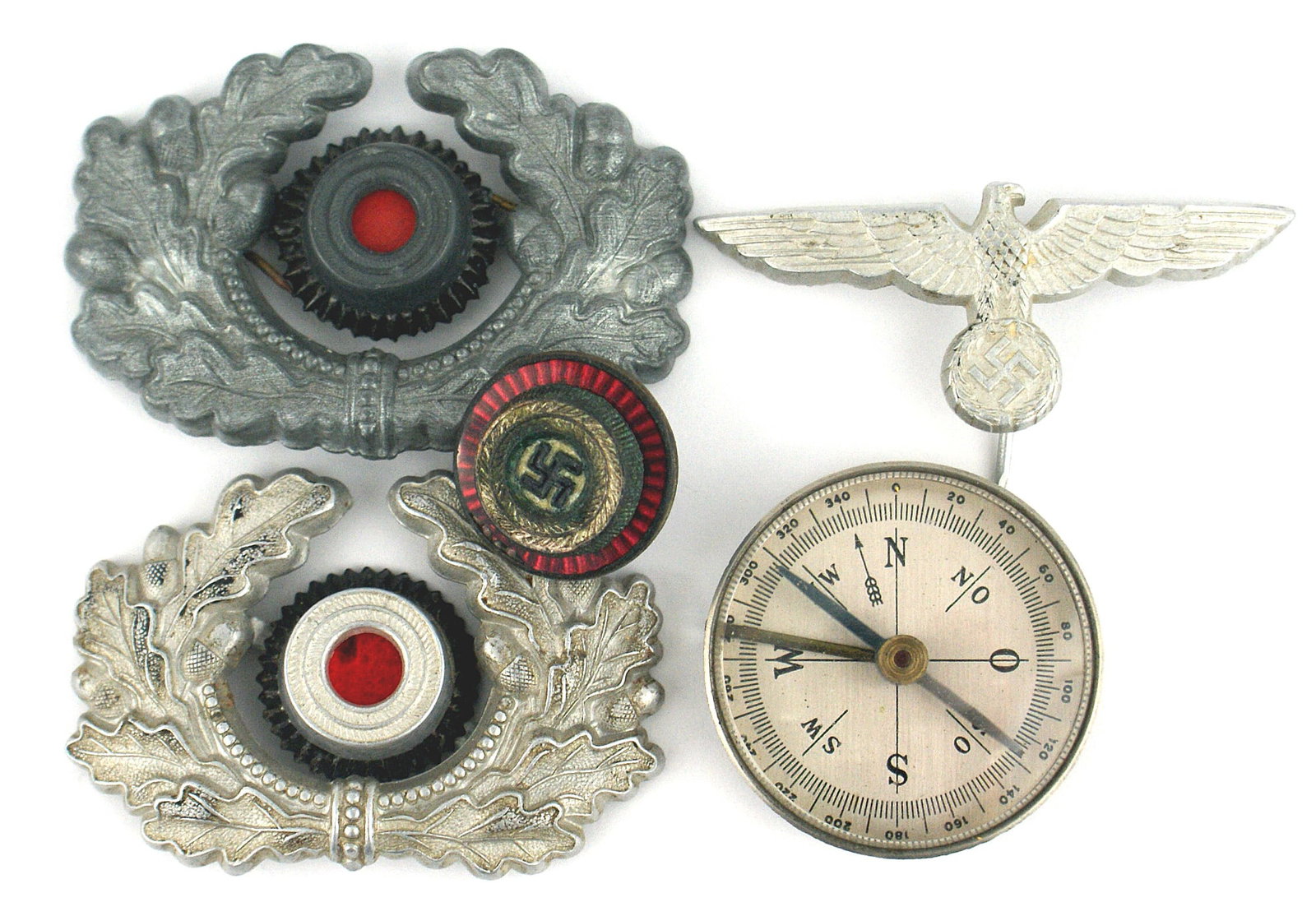 German WWII peaked cap insignia NSDAP: E-047 Lot of German Third Reich peaked cap insignia: (1) N.S.D.A.P. official enameled swastika within a silvered ring with an outer red enameled background. Reverse marked "RZM" and "M1/34". With two 
