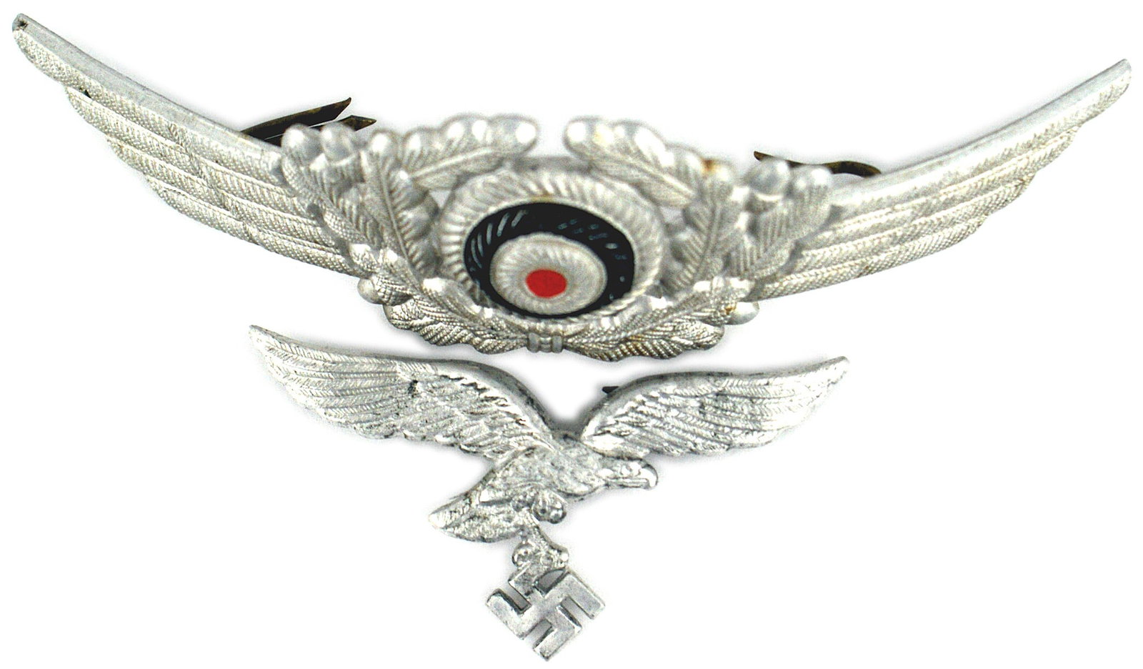 Set of German WWII Luftwaffe peaked cap insignia: E-050 Set of German WWII Luftwaffe peaked cap insignia: (1) Aluminum flying eagle holding a swastika. Two reinforced pins on reverse. (2) White metal winged oak leaf wreath with a black circled red ro