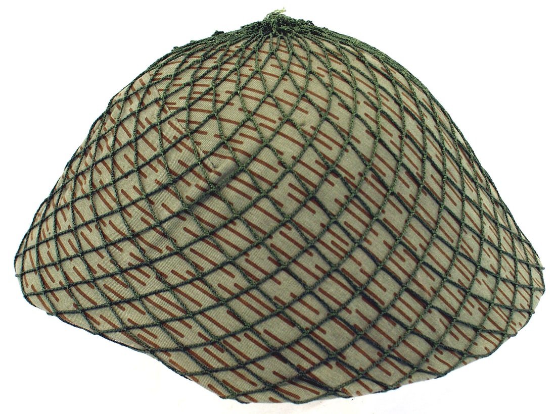 DDR East Germany Army helmet: E-071 DDR (East Germany) helmet. Field-gray finish. Plastic frame holds clean leather liner. Two "Y" section leather liner. With linear pattern, cloth camouflage cover and green net. Excellent. I