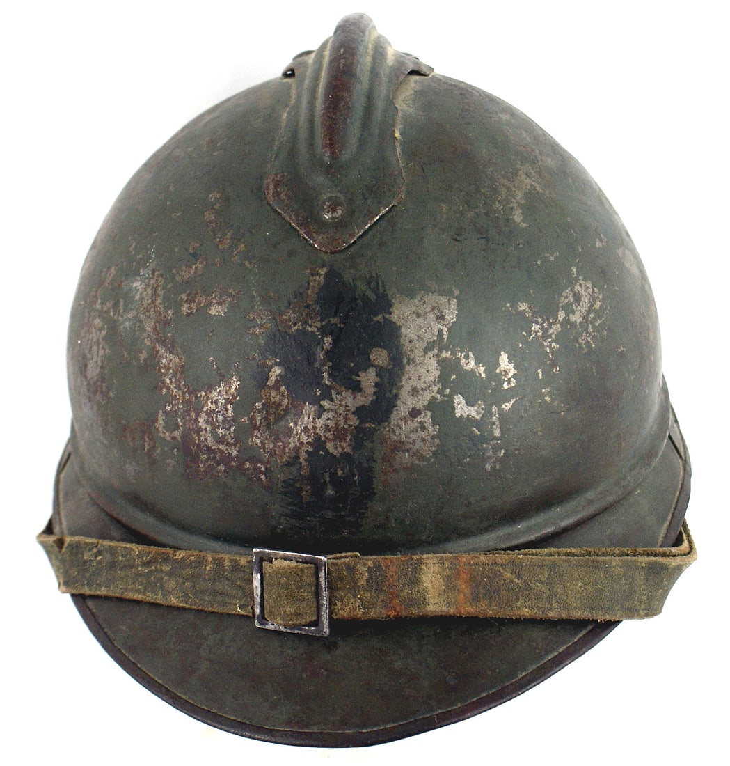 French WWI combat used Adrian helmet: E-073 French WWI combat used Adrian helmet. Shows wear but retains 60% of the feld-grau finish. Front badge was removed. Original leather chinstrap. Six tongue tan leather liner is probably a period r