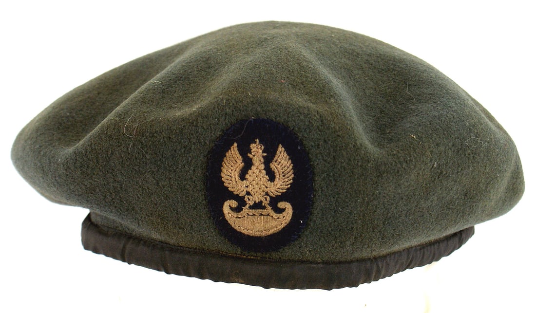 Polish WWII beret: E-084 Polish WWII beret. Green wool with black cloth lining with printed "BRIT...LTD." Dated "1943" and marked with a broad arrow in between "W-N-D-119". Embroidered silver-gray crowned Polish eagle o