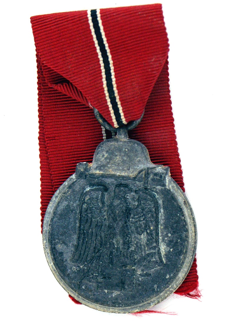 German WWII Eastern Front Medal: B-068 German WWII Eastern Front Medal. Obverse: Helmet/stick grenade above a large relief eagle/swastika. Reverse: "WINTERSCHLACHT IM OSTEN 1941-1942". With ribbon. II