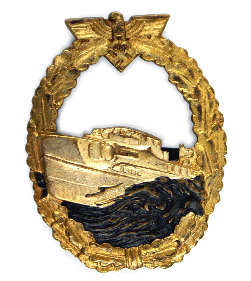 German WWII Navy 1st type E-Boat Badge: B-076 German WWII Navy 1st type E-Boat Badge. Open gold oak leaf wreath, eagle/swastika at top - holding a silver E-Boat cutting through darkened waves within the wreath. Dished reverse with a gun-blu