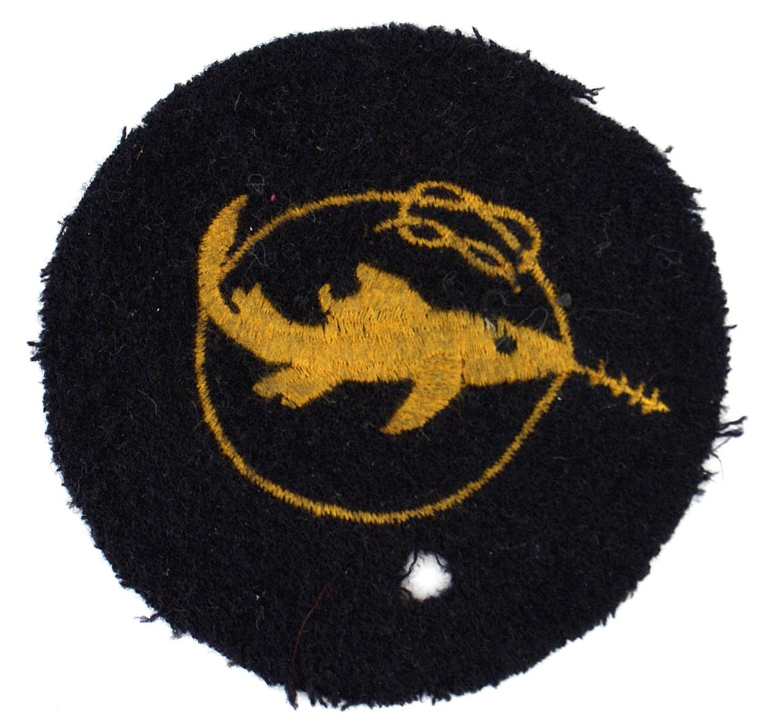 German WWII Navy Frogman Badge 1st Level: B-089 German WWII Navy "Kleinkampfverbande" or "Bewahrungsabzeichen" (Proof of Competence) 1st Level embroidered badge. Yellow-gold thread embroidered swordfish swimming across a rope loop on a round 