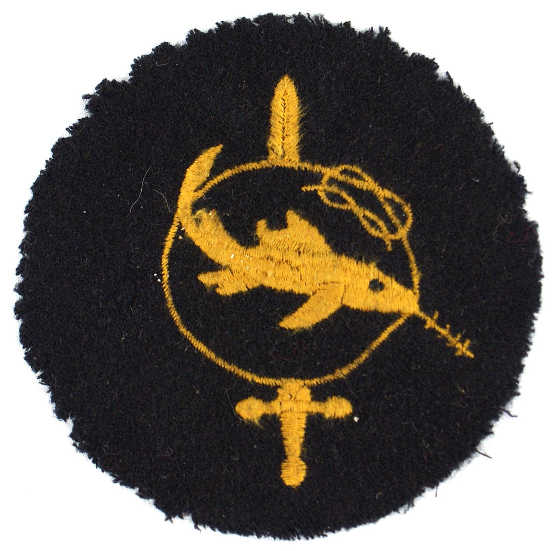 German WWII Navy Frogman Badge 2nd Level: B-090 German WWII Navy "Kleinkampverbande" or "Bewahrungsabzeichen" (Proof of Competence) 2nd Level embroidered badge. Yellow-gold thread embroidered swordfish swimming across a rope loop being pierce