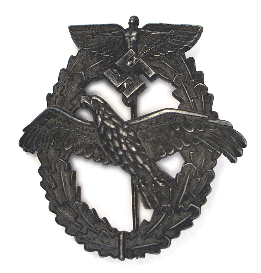 German WWII NSFK Pilot Badge Powered Aircraft: B-098 Third-Reich N.S.F.K. Pilot's Badge for Powered Aircraft - 1943. Struck in gray metal showing excellent detail. Winged figure/swastika on a convex open oak leaf wreath - holding a flying eagle. R