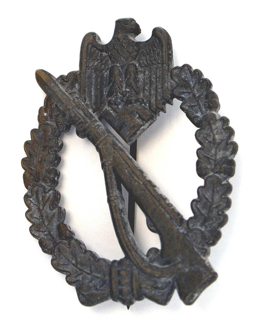German WWII Infantry Assault Badge Silver: B-099 German WWII Infantry Assault Badge - Silver. Eagle/swastika at top of an open oak leaf wreath - holding a rifle with a fixed bayonet. Solid type with a muted finish. Reverse marked "WH". II