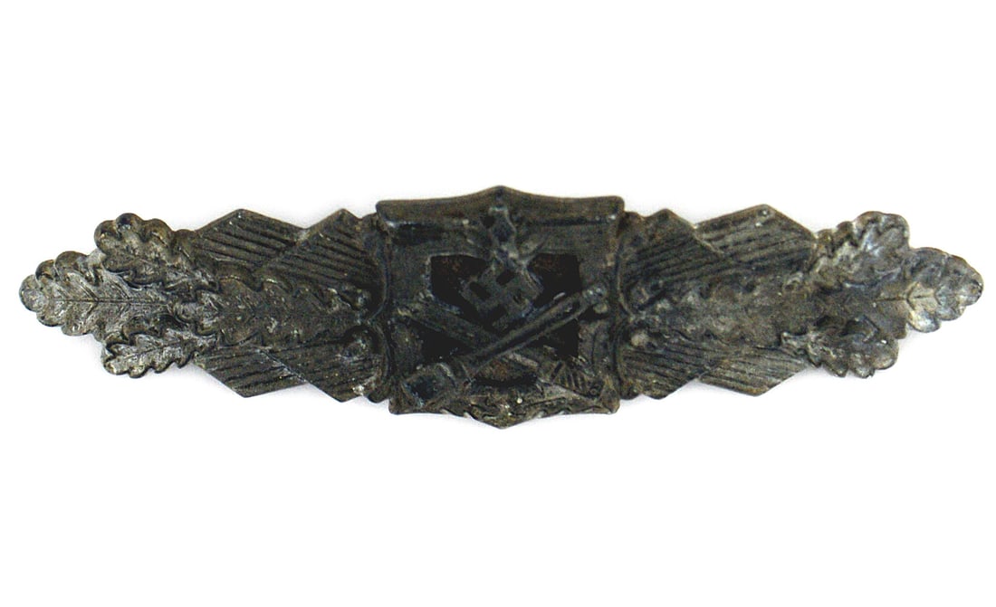 German WWII Combat Clasp: B-107 German WWII Combat Clasp. Eagle/swastika over crossed bayonet and "potato masher" in the center with a horizontal spray of oak leaves on each side. Aged and worn. Minute silver specks are the on