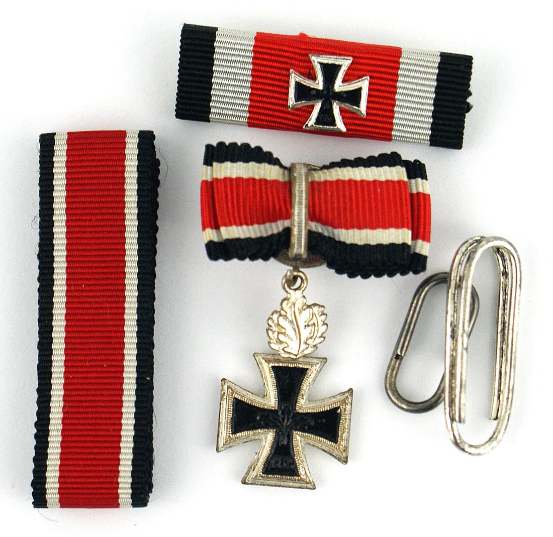Lot of German 1957 accessories Knights Cross: B-119 Lot of German 1957 accessories related to the Knight's Cross of the Iron Cross awarded during WWII: (1) Buttonhole ribbon device with a miniature 1939 Knights Cross with Oak Leaves. (2) Pin-back