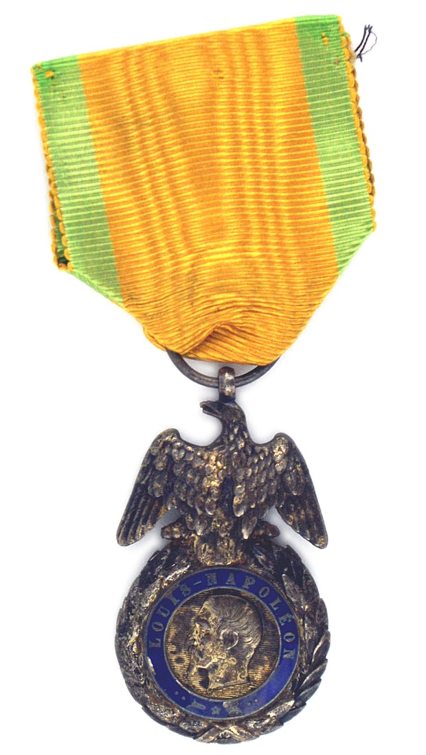 France Military Medal Type I 1852-1870: B-131 France. Military Medal Type I 1852-1870. Circular silver gilt laurel wreath. Center medallion is a side profile of Louis Napoleon. Reverse has "Valor and Discipline". A well defined eagle is per