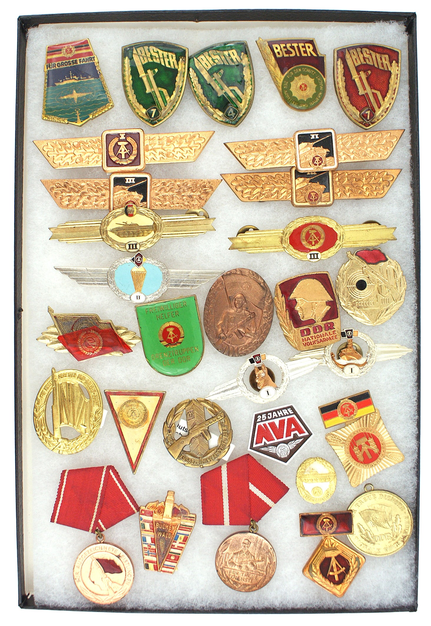 Frame of 30 DDR East German badges Panzer Navy: B-141 Frame of 30 DDR (East Germany) badges. Includes: Commemorative BUCHENWALD K.Z. Badge; "BESTER" NVA 1st Award Exemplary Soldier; "BESTER" Border Trooper - Exemplary 1st and 4th; NVA 2nd Series Pa