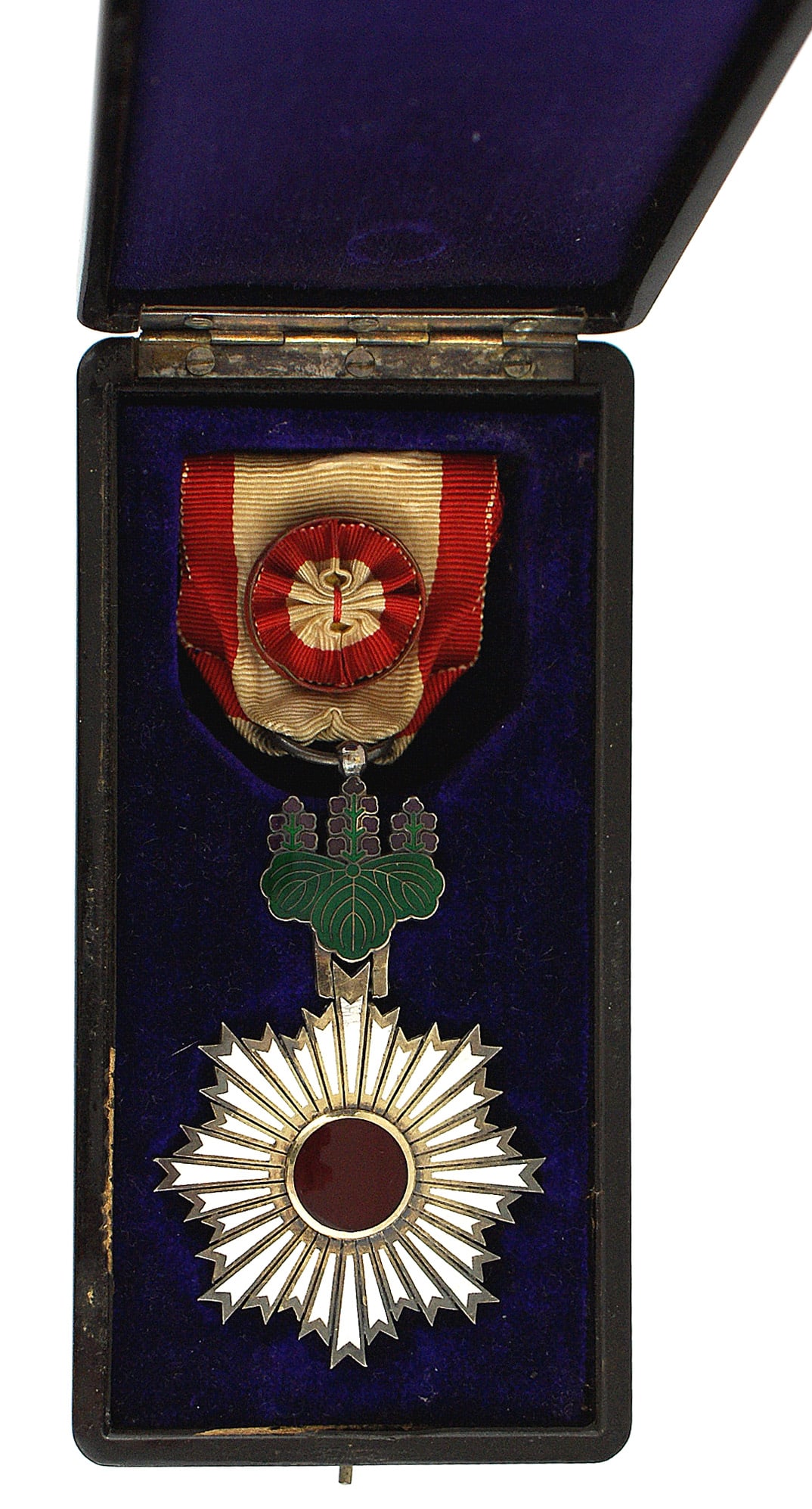 Japan Order of the Rising Sun 4th Class: B-152 Japan Order of the Rising Sun 4th Class. Red glass cabochon stone set into a starburst of silver outlined white enameled rays. Attached to the top is an enamel pendant of green Paulownia leaves 