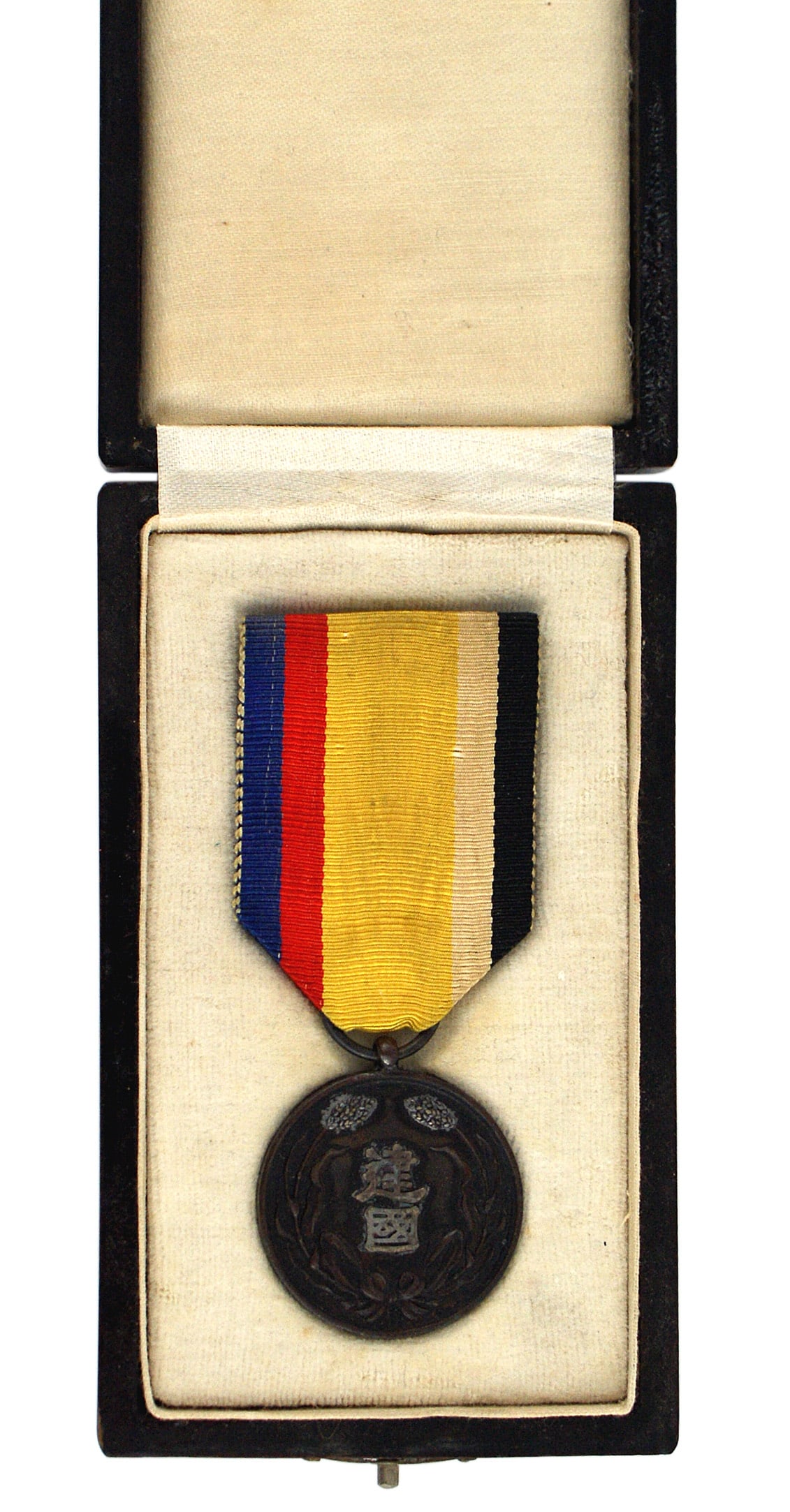 Japan Manchuko National Foundation Medal: B-157 Japan, Manchuko National Foundation Medal. Obverse bears two silver characters in center of the bronze award. Blue-red-yellow-white-black ribbon. Black lacquered presentation case. Gilt kanji on