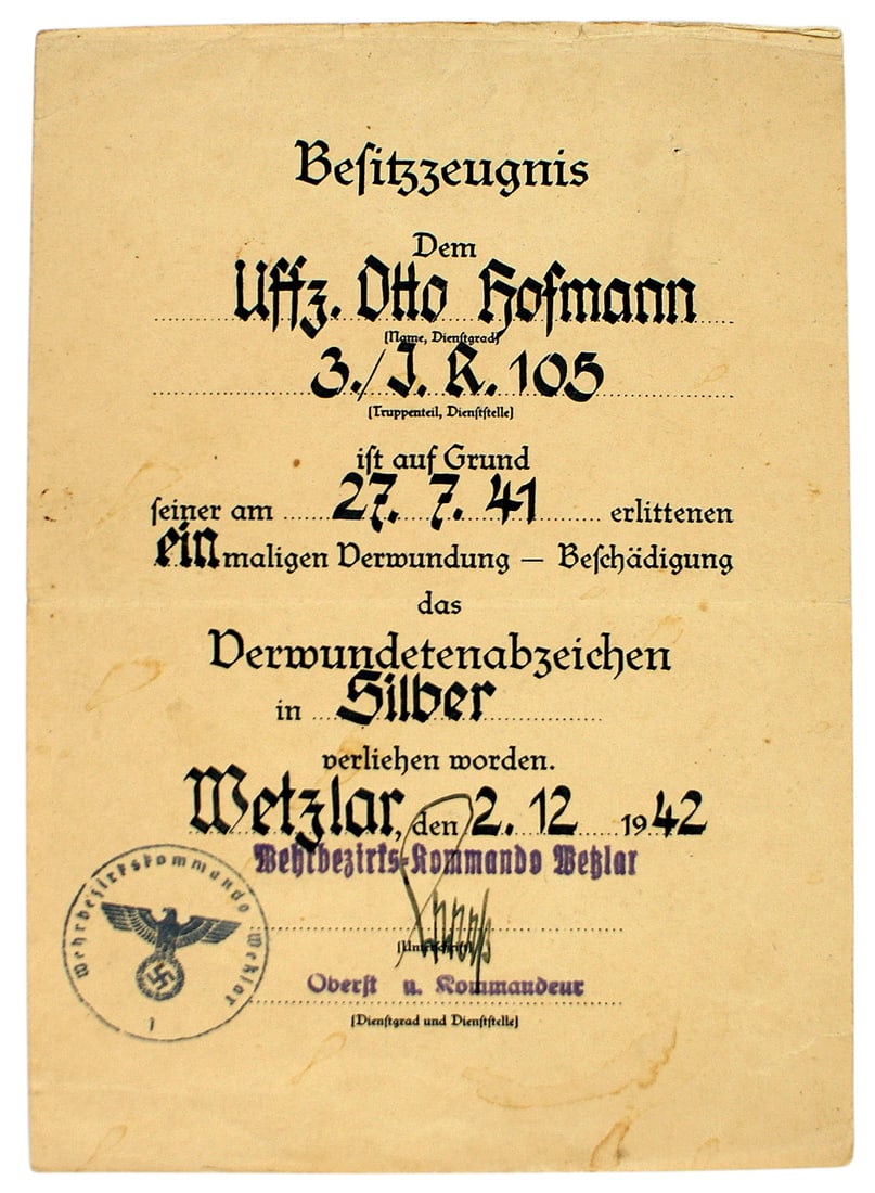 German WWII document Silver Wound Badge: C-012 German WWII Award document for the Silver Wound Badge. Ink hand printed to NCO "Otto Hofmann" of the 105th Infantry Regiment. Awarded in Wetzlar on 2.12 1942. Signed by a Colonel and Kommandeur.