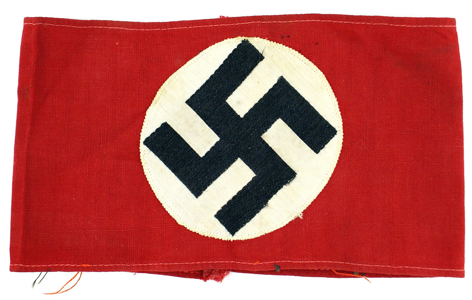 German WWII NSDAP armband: H-008 German Third Reich N.S.D.A.P. armband. Bevo embroidered black swastika on a 3 3/8" diameter white cloth disc sewn to the 4" wide red band. Was removed from a tunic. Some threads remain. II