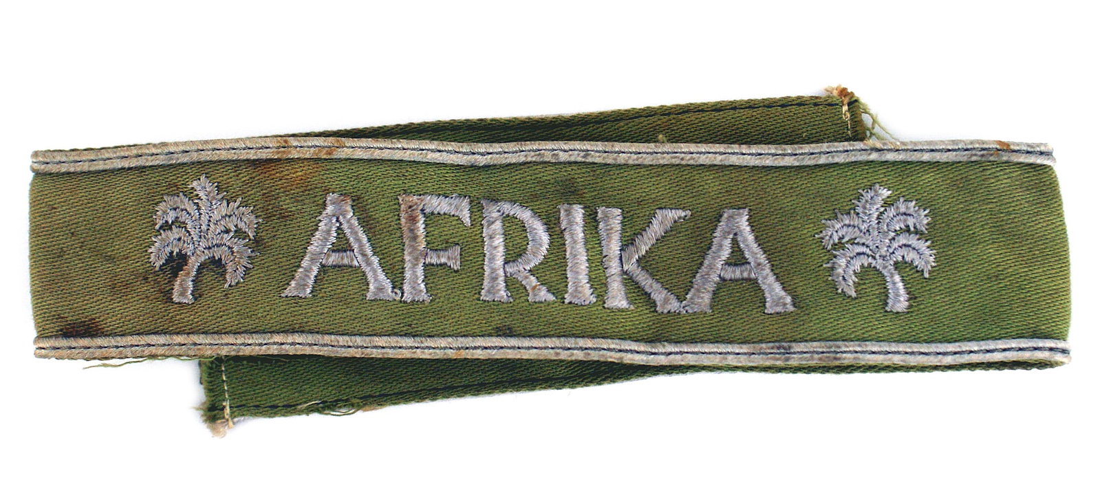 German WWII AFRIKA cufftitle: H-019 German WWII "AFRIKA" cufftitle. Awarded to replace the earlier Afrika Korps cufftitle for 6 months served in North Africa or was wounded or incapacitated. (The award was stated to be a soft khak