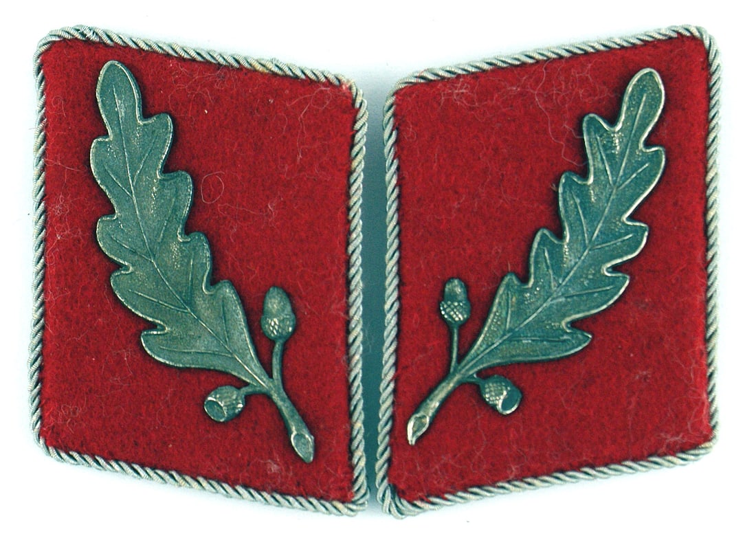 German WWII SA Fuhrer Staff 1933 collar tabs: H-029 Third-Reich SA Fuhrer (Staff) 1933 collar tabs. Single metal silver oak leaf (patina) on a carmine tab with thin silver cord piping. Pair. II+