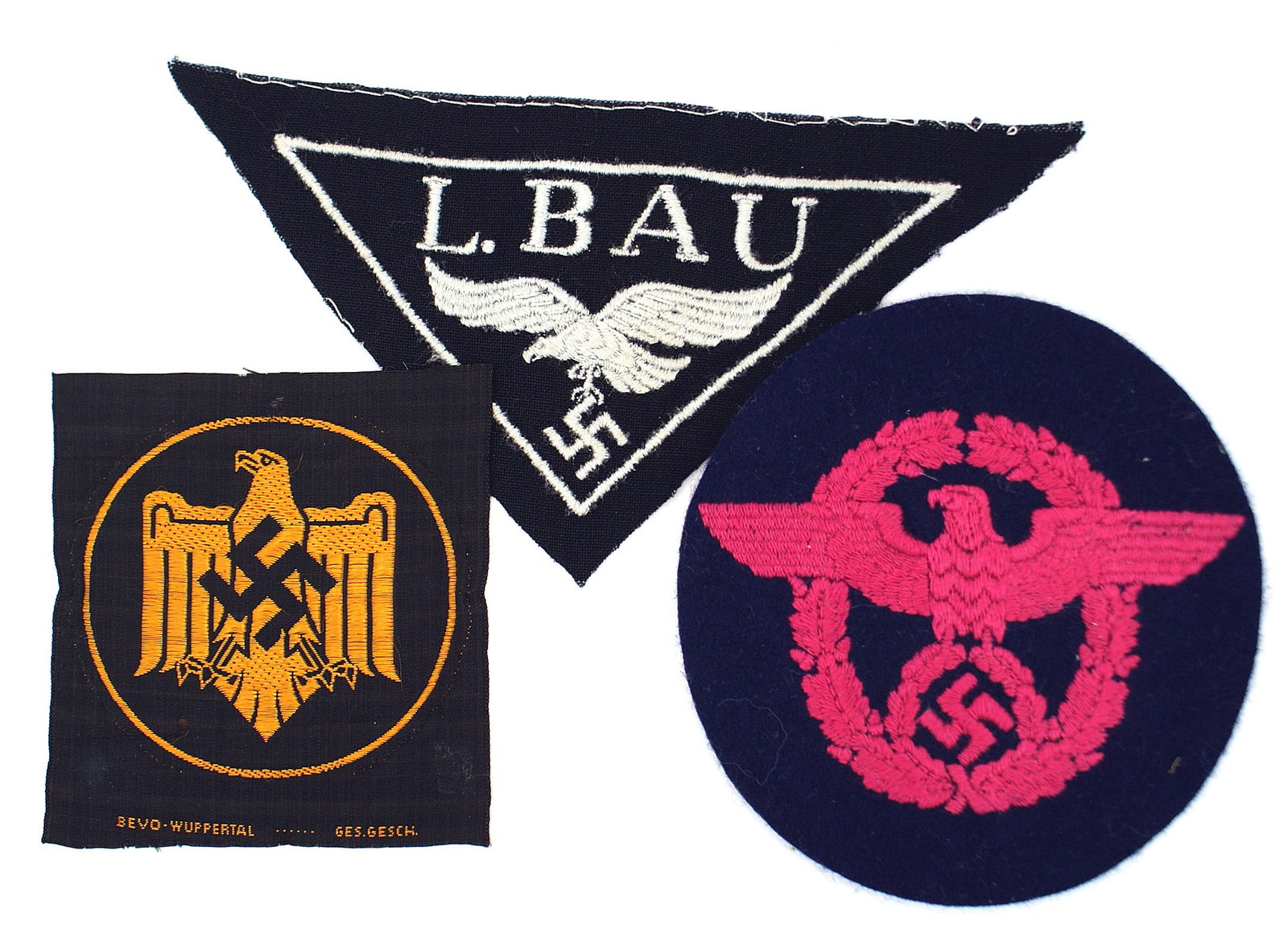 3 German WWII organization cloth eagles: H-041 Lot of 3 German WWII organizational eagle insignia: (1) Luftwaffe Construction Unit. Embroidered silver-gray "L. BAU" over a flying inverted triangle. (2) Fire Police. Embroidered carmine eagle/