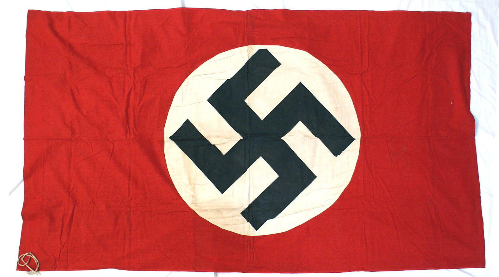 German WWII NSDAP flag: H-049 German Third Reich flag. Large black printed Swastika on a 30" wide white roundel. (Has been cleaned but has some faint residue.) Wide pole sleeve for a pole. 11" cloth pole ties on one side. 41