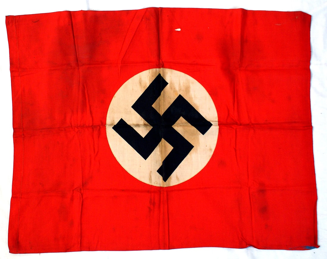 German WWII NSDAP flag: H-050 German Third Reich N.S.D.A.P. flag. Printed black swastika on a white roundel sewn to a red field. 30" x 23" with a cord or pole sleeve. Two minor white dots and revers white roundel have a ligh