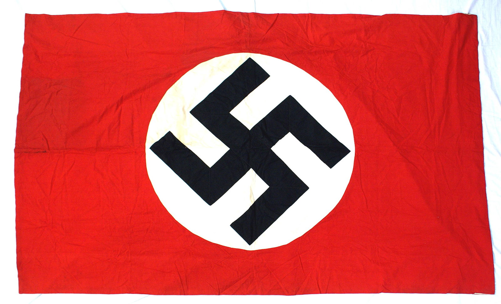 German WWII huge NSDAP flag: H-051 German Third Reich huge N.S.D.A.P. flag. Sewn black cloth swastika on a 34" diameter white roundel. Red field size 48" x 77". Wide pole sleeve. Some light foxing on the white roundel, still woul