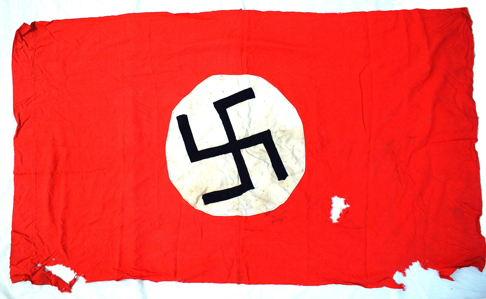 German early WWII wall banner: H-052 German early Nazi wall banner, 15" diameter white roundel sewn to a 50" x 29" red field. Unusual 1" wide black ribbon, sewn swastika. One side with a pole/cord sleeve at the top. This type of fl