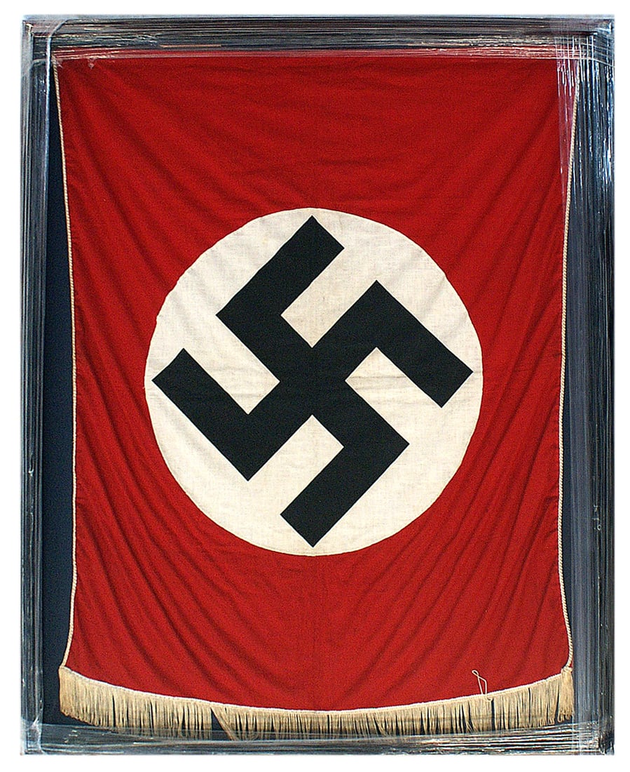 German WWII NSDAP rostrum banner: H-054 German Third Reich N.S.D.A.P. rostrum banner. Large black swastika on a 18" diameter white roundel sewn to a red field, with white cord piping. Bottom has a 3" white fringe. Mounted in a wood fr