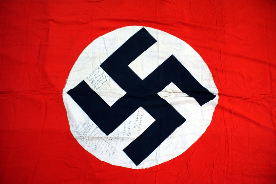 German WWII NSDAP banner: H-057 German Third Reich N.S.D.A.P. banner. Large printed black swastika on a 26" diameter white roundel on a red field. The banner was cut at the top and bottom leaving a length of 98". GI's who capt