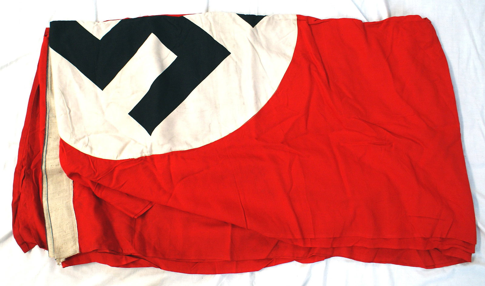 German WWII huge NSDAP stadium banner: H-059 German Third Reich huge N.S.D.A.P. building stadium banner. Large black swastika printed on a 30" diameter white roundel on a red field. 2 1/2 white sleeves. Approximately 195" x 46". II+