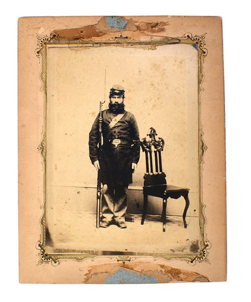 Large Civil War photo Union soldier: K-37 Large photo on a hardstock frame of a Union soldier standing at attention. Pronounced "U.S." belt buckle, shoulder strap/belt plate and rifle. 7 1/8" x 5 7/8" mounted on a studio hardstock mat. R