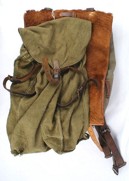 Lot of 2 German WWII Army backpacks: N-5 Lot of 2 Army backpacks: (1) Pony hide covered flap with double shoulder straps. Marked "Gebr. Kruger-Breslau 1939". Very good condition. (2) OD cloth, drawstring top with a small flap and sewn on