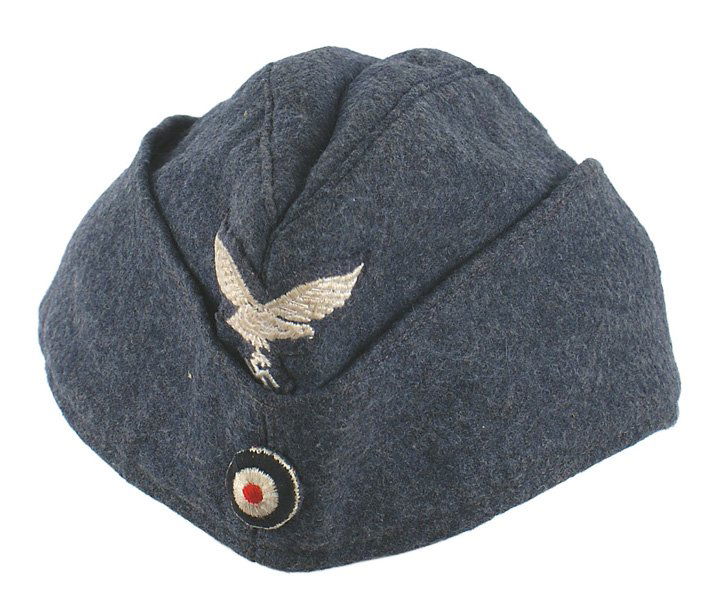 German WWII Luftwaffe EM overseas cap: E-106 German WWII Luftwaffe EM o'seas cap. Blue gray wool. Embroidered Luft/eagle/swastika and rosette. Satin type lining is stamped with maker "SCHLESISCHE MUTZENFABRIK...1942" II