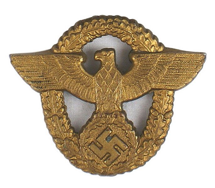 German WWII Harbor Police cap badge: E-157 German WWII Harbor Police peaked cap badge. Dull gold eagle/swastika on an open oak leaf wreath. Marked "F.B.L." II