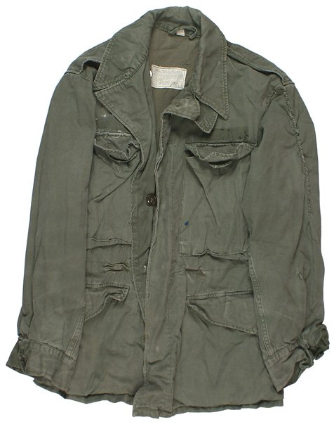 U.S. M1943 field jacket: F-64 U.S. M1943 field jacket O.D. cotton sateen with four button-down flap pockets and cuffs. Original cloth label in lining. 10" repaired tear up left sleeve. Tunic was washed. II-