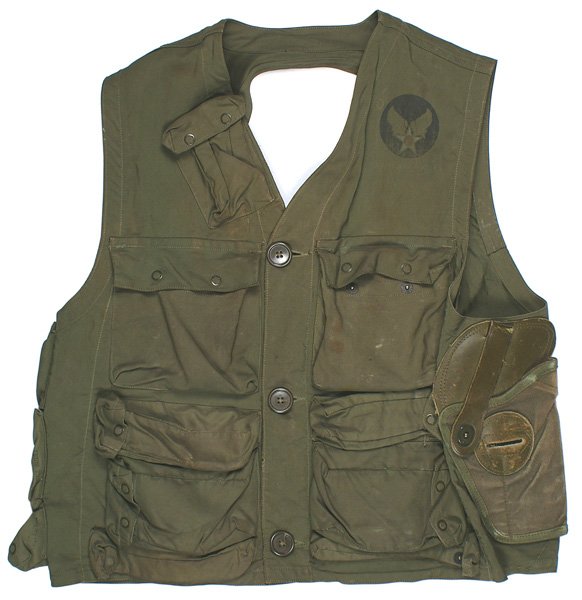 U.S. WWII Army Air Force pilot C-1 vest: F-107 U.S. WWII Army Air Force pilot's Type C-1 vest. Nylon, sleeveless, with 13 snap button pockets and a pistol holder. Winged star emblem on left front side. Shows some wear. About II