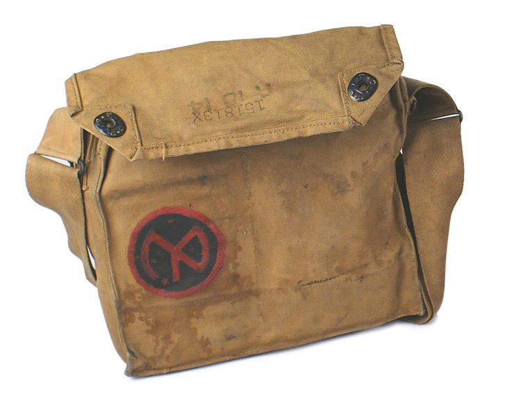 U.S. WWI gas mask: N-042 U.S. WWI gas mask. Bag is named to "SEAGT. C.R. CRISPIN - 55…". Reverse has a red and black painted 27th Division 3" diameter insignia. Mask complete. Bag is soiled from use. One post for a fl