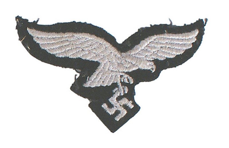 German WWII Goring Panzer M1943 eagle: E-259 German WWII Hermann Goring Panzer Division M43 cap eagle. Silver-gray eagle/swastika on a black background. Was removed from a cap. Some thread fragments remain. II